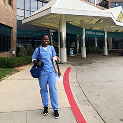 Exchange student pharmacist in blue scrubs outside main entrance to Lawrence Memorial Hospital