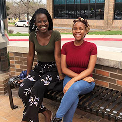 Two student pharmacists pose together seated on a bench at Lawrence Memorial Hospital