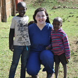 student pharmacist poses with two children